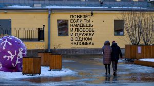 A couple of people walking in front of a building
